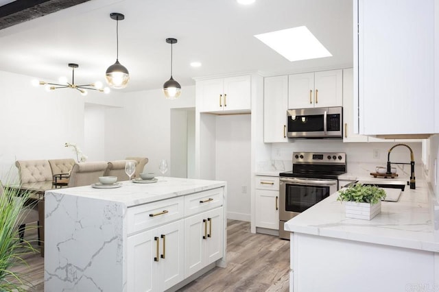 12049 Coping Pl, Lakeside, CA 92040 - kitchen with stainless steel appliances, a skylight, light wood finished floors, white cabinetry, and recessed lighting