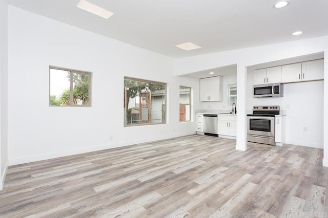12049 Coping Pl, Lakeside, CA 92040 - unfurnished living room with a sink, light wood-style floors, recessed lighting, and baseboards