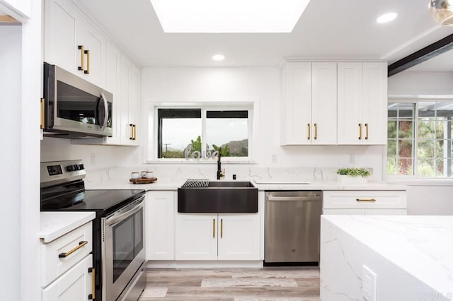 12049 Coping Pl, Lakeside, CA 92040 - kitchen featuring appliances with stainless steel finishes, a sink, light stone countertops, light wood finished floors, and white cabinets