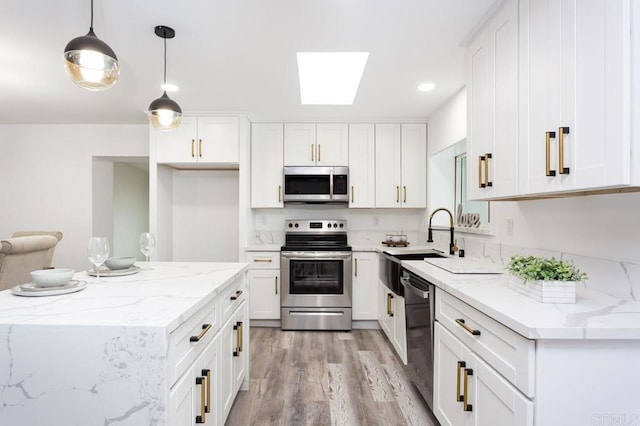 12049 Coping Pl, Lakeside, CA 92040 - kitchen with stainless steel appliances, white cabinets, light wood finished floors, a skylight, and recessed lighting