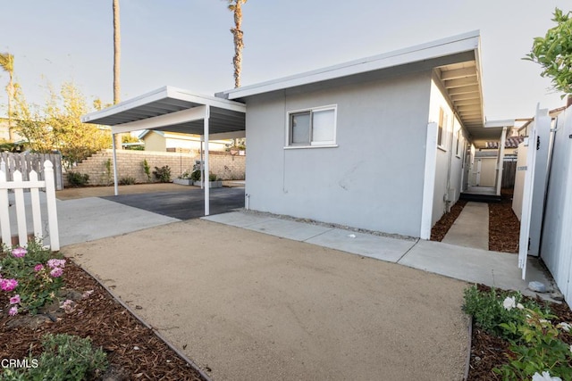 2256 Pierpont Blvd, Ventura, CA 93001 - view of property exterior featuring a carport, stucco siding, driveway, and a fenced backyard