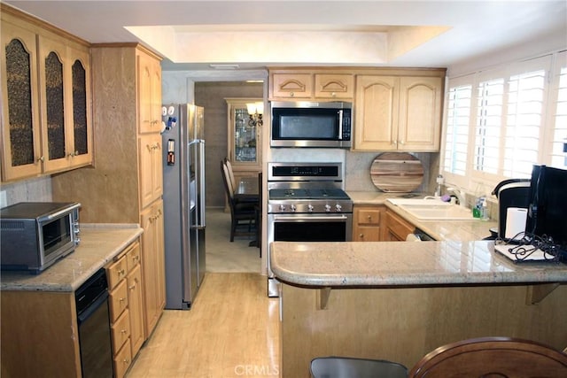 5325 Lindley Ave Unit 202, Tarzana, CA 91356 - kitchen with appliances with stainless steel finishes, light brown cabinets, a sink, and a peninsula