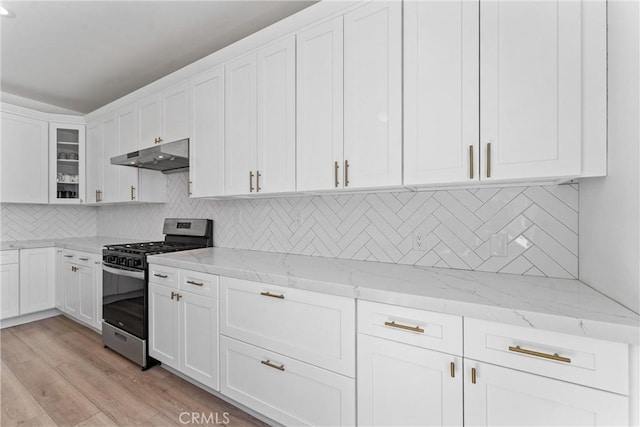 8798 Crest View Dr, Corona, CA 92883 - kitchen featuring stainless steel range with gas stovetop, under cabinet range hood, white cabinets, light wood-style floors, and light stone countertops