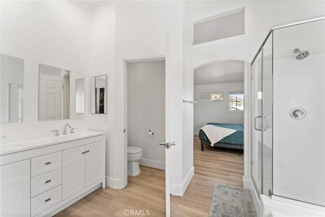 8798 Crest View Dr, Corona, CA 92883 - ensuite bathroom featuring wood finished floors, a shower stall, double vanity, a high ceiling, and toilet