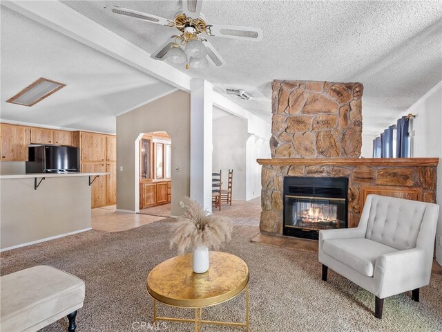 8307 Arrowhead Lake Rd, Hesperia, CA 92345 - living area with light carpet, a ceiling fan, a textured ceiling, a stone fireplace, and arched walkways