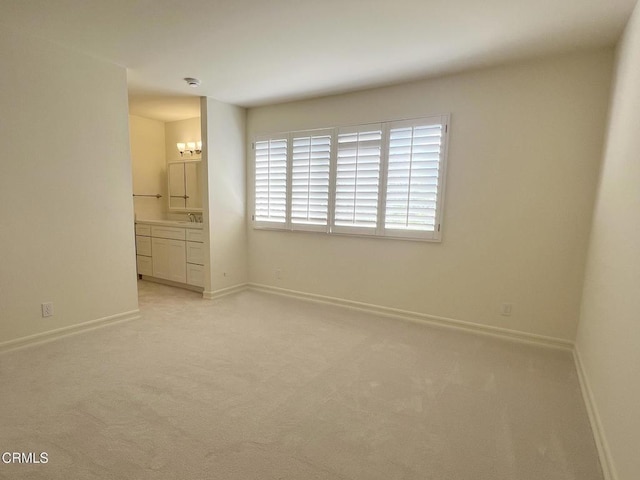 528 N Orange Grove Blvd, Pasadena, CA 91103 - unfurnished bedroom with baseboards, light colored carpet, ensuite bathroom, and a sink