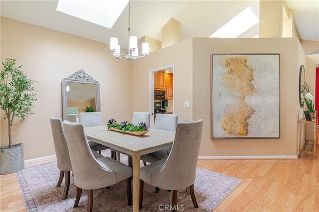 1049 Fairview Ave Unit 5, Arcadia, CA 91007 - dining room featuring a chandelier, a skylight, light wood finished floors, baseboards, and high vaulted ceiling