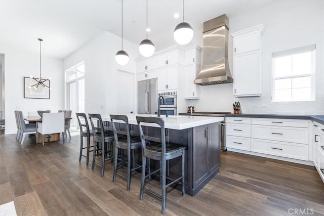 4029 Bernardo Dr, San Luis Obispo, CA 93401 - kitchen featuring wall chimney range hood, dark wood finished floors, stainless steel appliances, and a chandelier