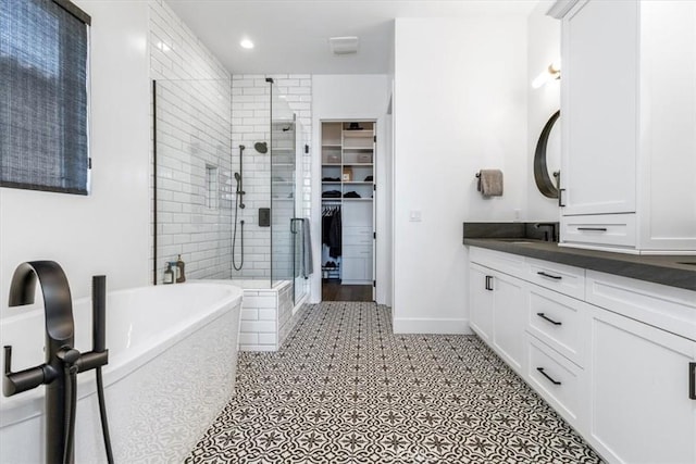 4029 Bernardo Dr, San Luis Obispo, CA 93401 - bathroom with a stall shower, vanity, a freestanding tub, a walk in closet, and baseboards