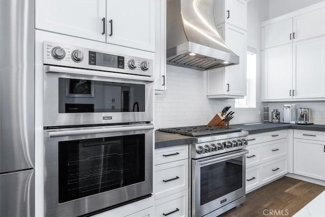 4029 Bernardo Dr, San Luis Obispo, CA 93401 - kitchen with wall chimney exhaust hood, appliances with stainless steel finishes, dark countertops, and white cabinetry