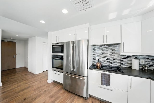 510 First Ave Unit 402, San Diego, CA 92101 - kitchen featuring freestanding refrigerator, black electric cooktop, backsplash, white cabinetry, and dark countertops