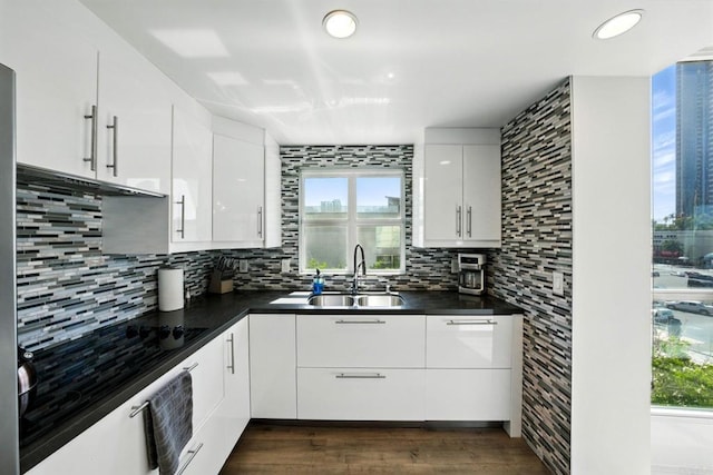 510 First Ave Unit 402, San Diego, CA 92101 - kitchen featuring a sink, decorative backsplash, dark countertops, white cabinets, and dark wood-style flooring