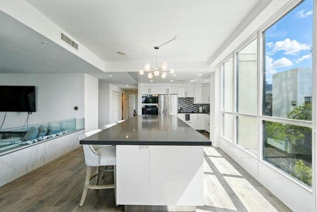 510 First Ave Unit 402, San Diego, CA 92101 - kitchen featuring light wood-type flooring, appliances with stainless steel finishes, dark countertops, a chandelier, and recessed lighting