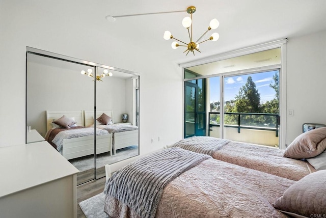 510 First Ave Unit 402, San Diego, CA 92101 - bedroom featuring a chandelier, access to exterior, wood finished floors, and a closet