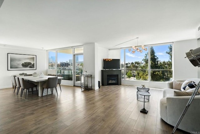 510 First Ave Unit 402, San Diego, CA 92101 - living area with a chandelier, dark wood-style floors, a glass covered fireplace, and expansive windows