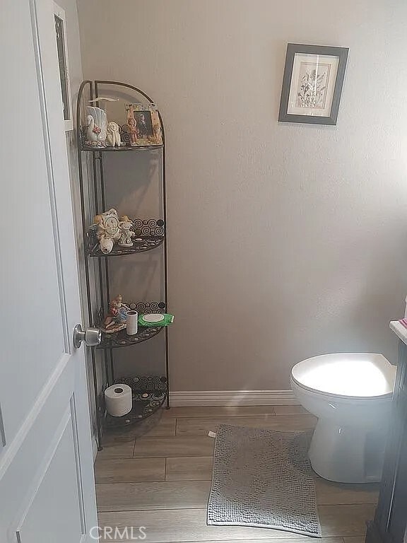 13914 Prichard St, La Puente, CA 91746 - bathroom with wood finished floors, toilet, and baseboards