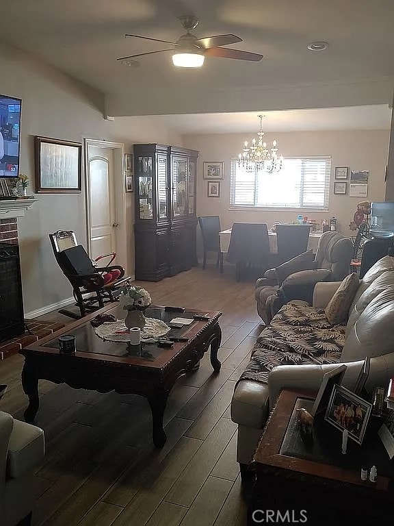 13914 Prichard St, La Puente, CA 91746 - living area with wood finished floors, a ceiling fan, and a chandelier