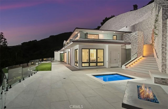 31 N Vista De Catalina, Laguna Beach, CA 92651 - back of property featuring stairs, an outdoor fire pit, a patio area, an outdoor pool, and stucco siding