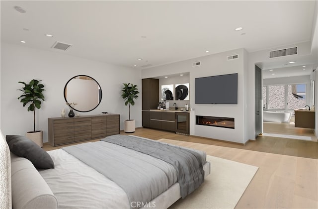 31 N Vista De Catalina, Laguna Beach, CA 92651 - bedroom featuring wine cooler, light wood-type flooring, recessed lighting, a sink, and a glass covered fireplace