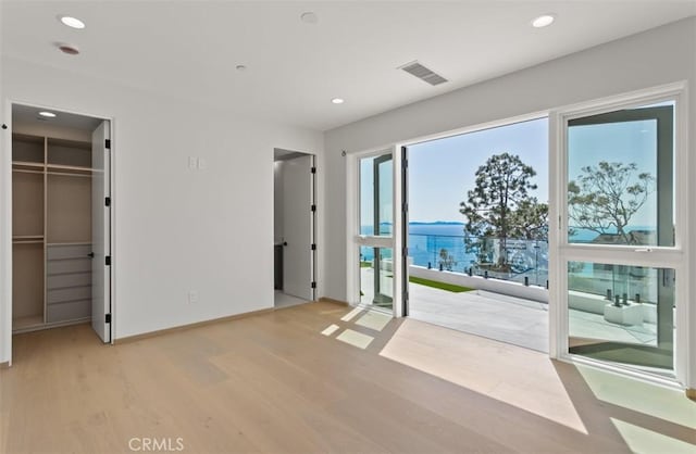 31 N Vista De Catalina, Laguna Beach, CA 92651 - unfurnished bedroom with light wood-type flooring, access to outside, a spacious closet, a water view, and recessed lighting