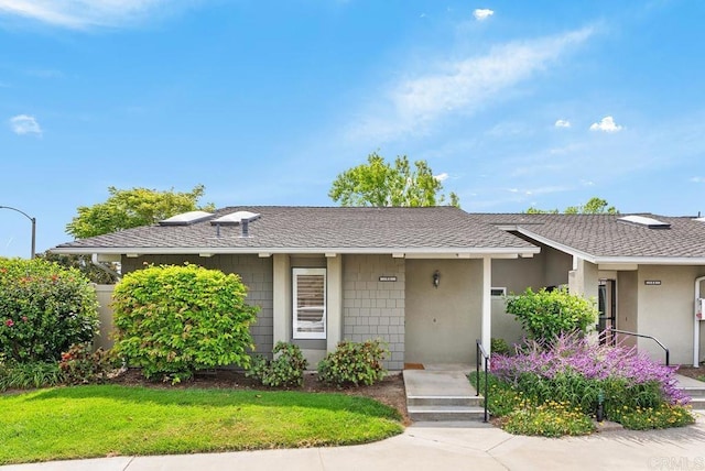 8933 Yolo Cir Unit 1308-A, Huntington Beach, CA 92646 - view of front of house featuring roof with shingles, a front lawn, and stucco siding