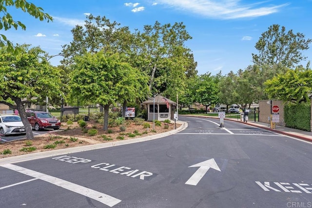 8933 Yolo Cir Unit 1308-A, Huntington Beach, CA 92646 - view of asphalt street featuring curbs, traffic signs, street lighting, and a gated entry
