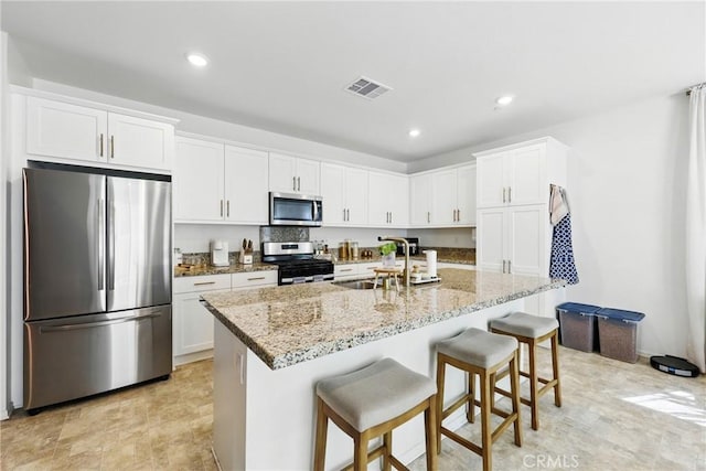 1782 Park Place Ln, Riverside, CA 92501 - kitchen featuring stainless steel appliances, a sink, white cabinets, light stone countertops, and recessed lighting