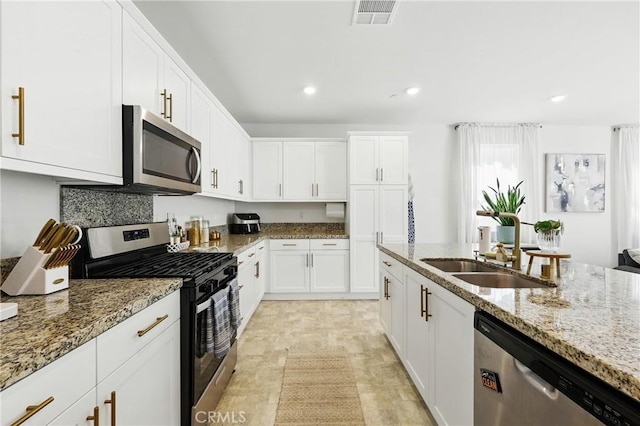 1782 Park Place Ln, Riverside, CA 92501 - kitchen with stainless steel appliances, a sink, light stone counters, white cabinets, and recessed lighting