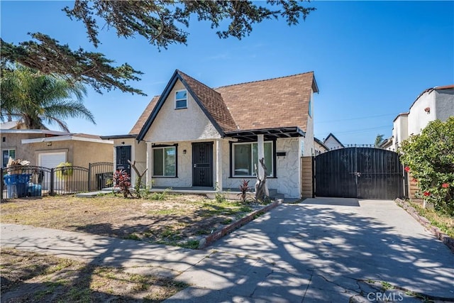 407 W 107th St, Los Angeles, CA 90003 - tudor house featuring a gate, stone siding, a shingled roof, and stucco siding