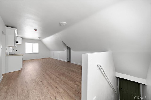 407 W 107th St, Los Angeles, CA 90003 - bonus room with light wood finished floors, lofted ceiling, a sink, and baseboards