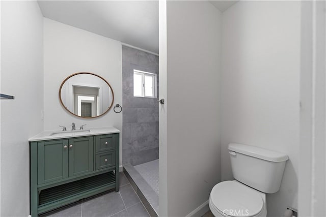 407 W 107th St, Los Angeles, CA 90003 - bathroom featuring toilet, vanity, a tile shower, tile patterned flooring, and baseboards