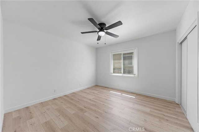 407 W 107th St, Los Angeles, CA 90003 - unfurnished bedroom featuring light wood-type flooring, baseboards, a closet, and a ceiling fan