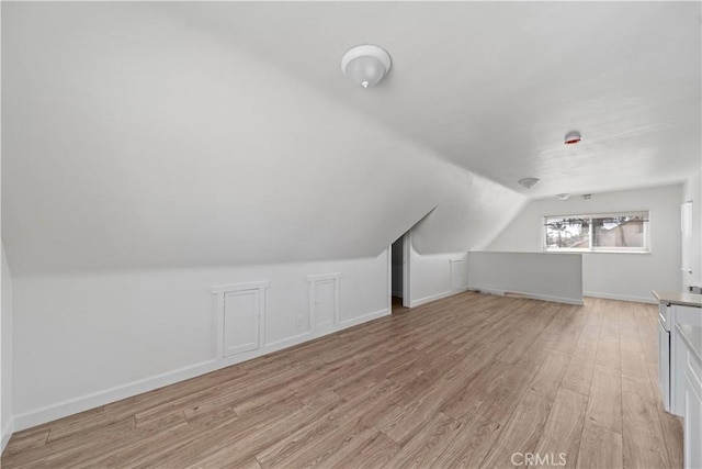 407 W 107th St, Los Angeles, CA 90003 - additional living space with light wood-style floors, vaulted ceiling, and baseboards