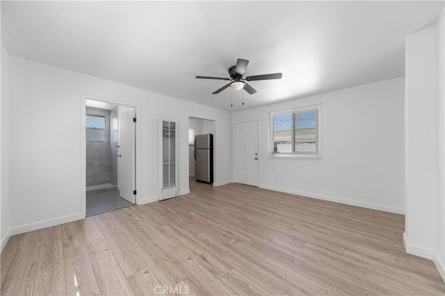 407 W 107th St, Los Angeles, CA 90003 - unfurnished bedroom with freestanding refrigerator, light wood-type flooring, baseboards, and connected bathroom