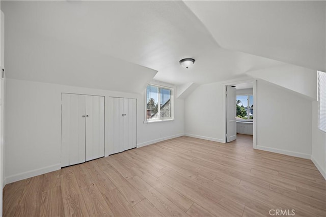 407 W 107th St, Los Angeles, CA 90003 - additional living space featuring lofted ceiling, healthy amount of natural light, light wood-type flooring, and baseboards