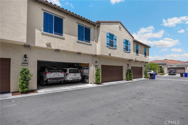 1095 W Buttercup Ln, Rialto, CA 92376 - back of property with stucco siding, an attached garage, and a tile roof