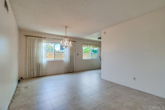 817 Cedar Ave, Chula Vista, CA 91911 - spare room with a chandelier, a textured ceiling, light tile patterned flooring, and baseboards