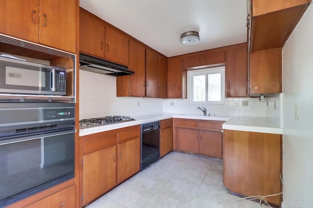 817 Cedar Ave, Chula Vista, CA 91911 - kitchen featuring black appliances, under cabinet range hood, tasteful backsplash, light tile patterned flooring, and brown cabinets