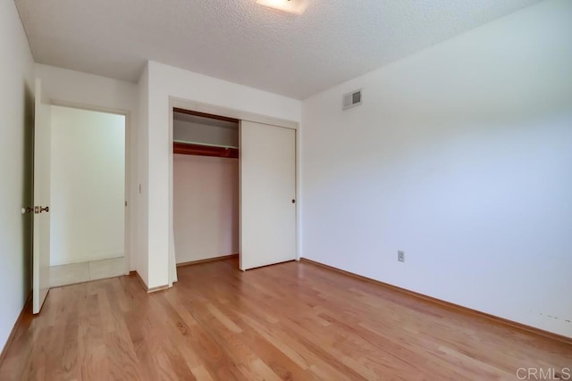 817 Cedar Ave, Chula Vista, CA 91911 - unfurnished bedroom with light wood-style floors, a closet, baseboards, and a textured ceiling