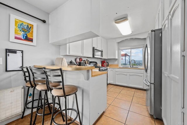 865 Worthington St, San Diego, CA 92114 - kitchen with appliances with stainless steel finishes, a sink, a peninsula, a kitchen breakfast bar, and white cabinetry