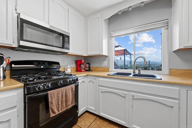 865 Worthington St, San Diego, CA 92114 - kitchen with black range with gas stovetop, stainless steel microwave, a sink, and white cabinets
