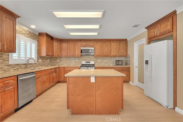 12415 Brianwood Dr, Riverside, CA 92503 - kitchen featuring stainless steel appliances, a sink, tasteful backsplash, a center island, and light wood-style floors