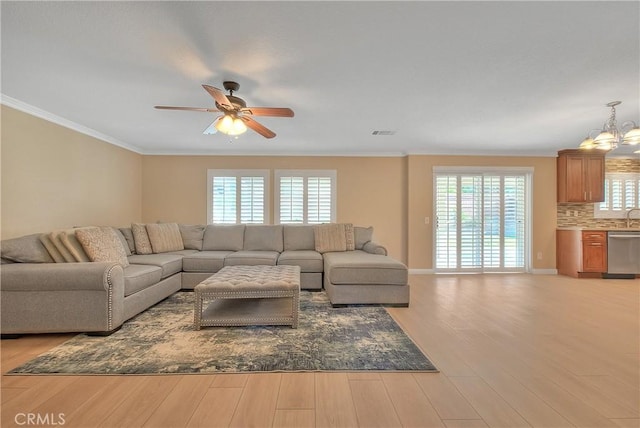 12415 Brianwood Dr, Riverside, CA 92503 - living room with light wood-style floors, ceiling fan, ornamental molding, a chandelier, and baseboards