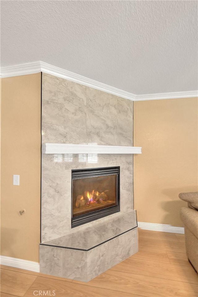 12415 Brianwood Dr, Riverside, CA 92503 - detailed view of baseboards, ornamental molding, a textured ceiling, a tile fireplace, and wood finished floors