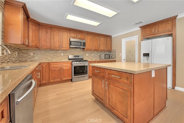 12415 Brianwood Dr, Riverside, CA 92503 - kitchen featuring appliances with stainless steel finishes, a sink, crown molding, brown cabinets, and backsplash