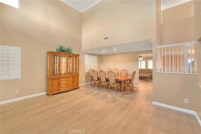 12415 Brianwood Dr, Riverside, CA 92503 - dining area featuring a towering ceiling, baseboards, light wood-style flooring, a ceiling fan, and ornamental molding