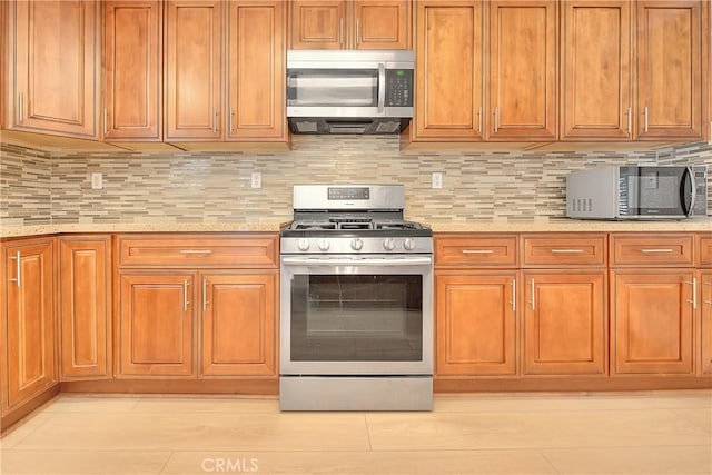 12415 Brianwood Dr, Riverside, CA 92503 - kitchen with appliances with stainless steel finishes, brown cabinetry, decorative backsplash, and light tile patterned floors