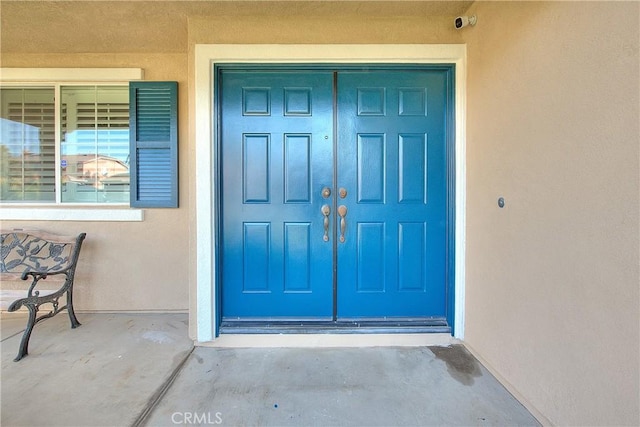 12415 Brianwood Dr, Riverside, CA 92503 - doorway to property featuring stucco siding and a security system