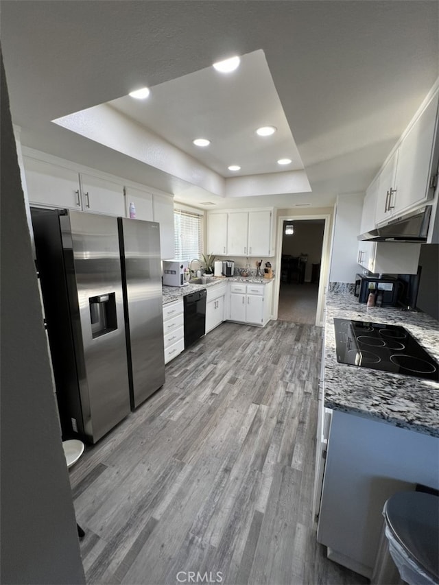 108 Limestone Rd, Claremont, CA 91711 - kitchen featuring black appliances, a tray ceiling, light wood-style floors, a sink, and light stone countertops