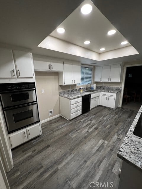 108 Limestone Rd, Claremont, CA 91711 - kitchen with a tray ceiling, double oven, dark wood finished floors, white cabinetry, and recessed lighting